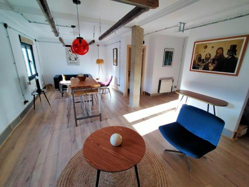 a living room with a blue chair and a table at Lotila Flats Mieres in Mieres