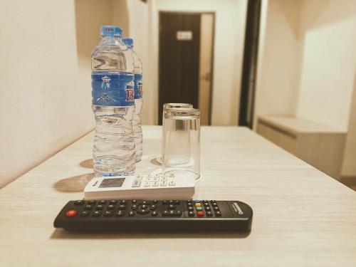 a bottle of water and a remote control on a table at Yunna Express in Geruntang