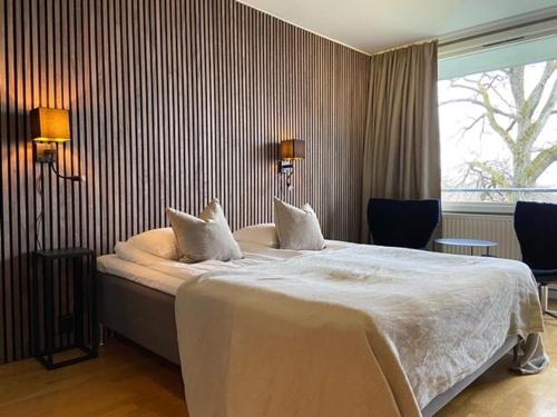 a bedroom with a large white bed with two pillows at Albert Kök Hotell & Konferens in Trollhättan