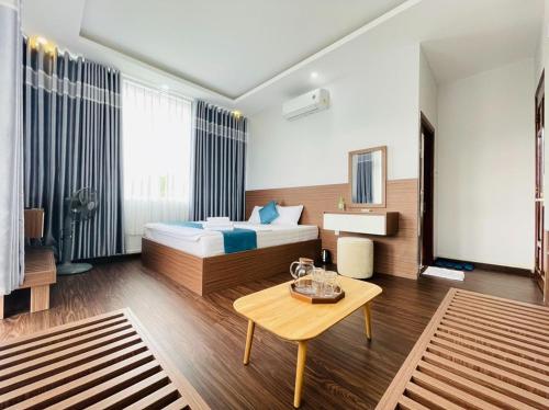 a hotel room with a bed and a table at Thanh Binh Hotel Con Dao in Con Dao