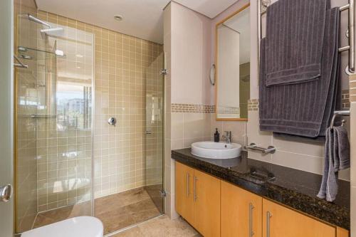 y baño con lavabo y ducha acristalada. en Juliette 208, en Ciudad del Cabo