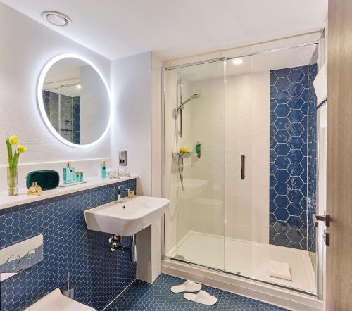 een badkamer met een wastafel en een douche bij The Grafton Hotel in Dublin