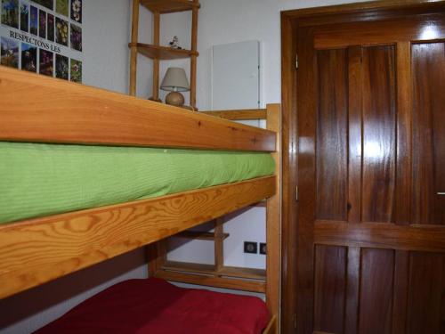 een slaapkamer met een stapelbed en een houten deur bij Studio Font-Romeu-Odeillo-Via, 1 pièce, 4 personnes - FR-1-580-20 in Font Romeu Odeillo Via