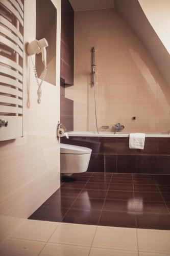 a bathroom with a sink and a bath tub at Młyn Jacka Hotel & Spa in Wadowice