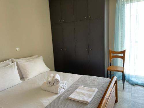 a bedroom with a bed with towels and a chair at Lenio’s in Karistos