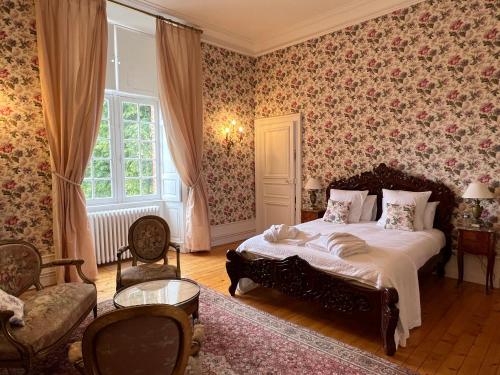 ルマンにある24H LE MANS Château de Lauresse chambres d'hôtes Luxeの花柄の壁紙を用いたベッドルーム1室(ベッド1台付)
