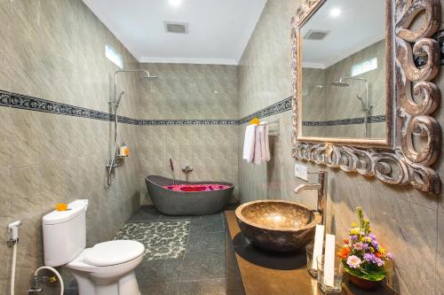 La salle de bains est pourvue d'une baignoire, de toilettes et d'un lavabo. dans l'établissement Pundi Kaya, à Ubud