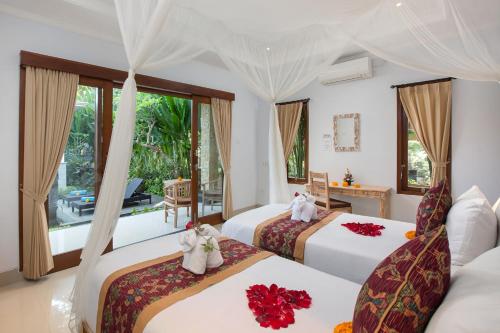 Cette chambre dispose de deux lits et d'un balcon. dans l'établissement Pundi Kaya, à Ubud
