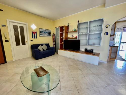 a living room with a blue couch and a tv at Casa Conchiglia in Vado Ligure