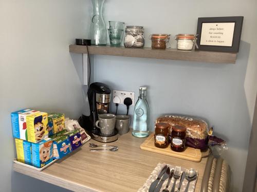 a shelf with a coffee maker and some food on it at The Den at Pinchbeck in Spalding