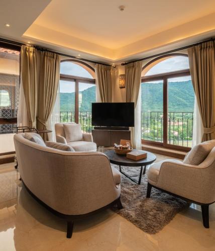 a living room with chairs and a television and large windows at Toscana Valley Castello Della Valle in Mu Si