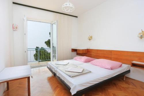 a bedroom with a bed and a large window at Rooms with a parking space Brela, Makarska - 17281 in Brela
