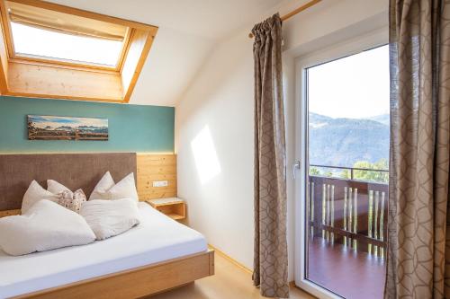 a bedroom with a bed and a large window at Residence Alpenrose in Bressanone