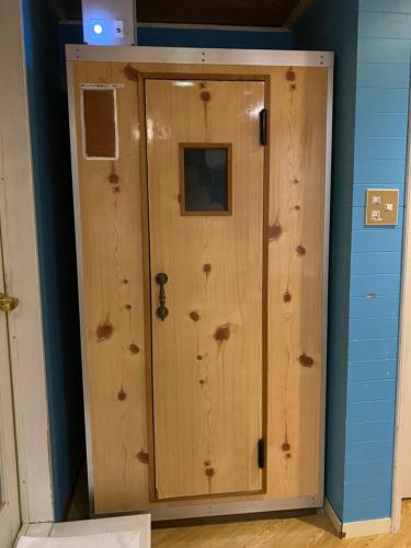 a wooden door in a room with a blue wall at ホテル艶グループ　富津店 in Futtsu