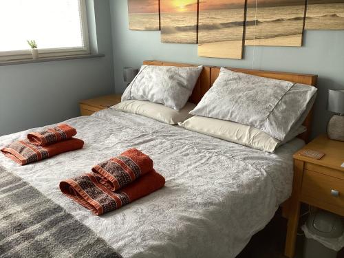 a bedroom with a bed with two pillows on it at The Den at Pinchbeck in Spalding