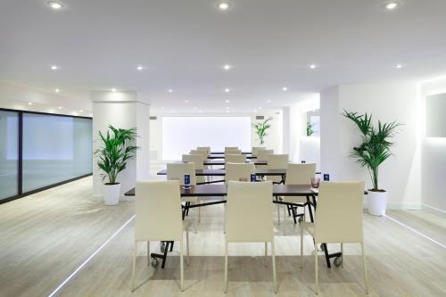a conference room with tables and chairs and plants at Hotel Palma Bellver , Affiliated by Meliá in Palma de Mallorca
