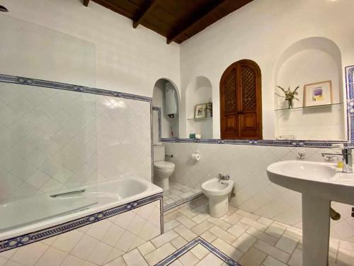 ein Badezimmer mit einer Badewanne, einem WC und einem Waschbecken in der Unterkunft La Casona de la Sierra in Higuera de la Sierra