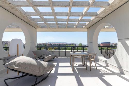 Habitación con balcón, cama y mesa. en Apartamentos Líbere Pamplona Yamaguchi en Pamplona