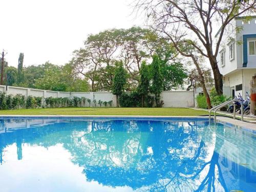 a large blue swimming pool in front of a house at HOTEL SHREE VILLA in Harsola