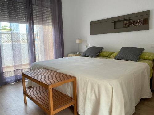a bedroom with a large bed with a table next to it at AGRADABLE CASA EN SAN JOSE in San José