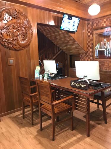 a desk with two monitors and chairs in a room at Seahouse Bali Indah Beach Inn in Kuta