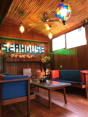 a restaurant with a table and blue chairs and a wellness sign at Seahouse Bali Indah Beach Inn in Kuta