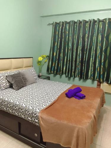 a bedroom with a bed with purple gloves on it at Budget Friendly Transient in Valley Mansions hosted by Aliyah in Cainta