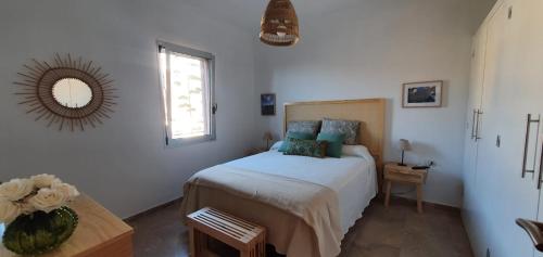 een slaapkamer met een bed en een spiegel aan de muur bij Casa Doris in San Sebastián de la Gomera