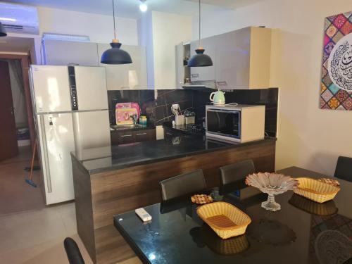 a kitchen with a dining table and a refrigerator at Azha Ain Sokhna apartment in Ain Sokhna