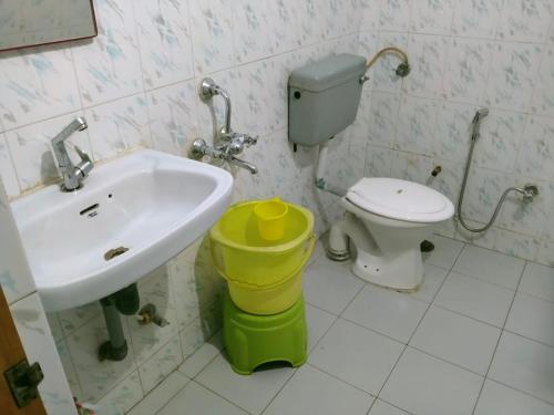 a bathroom with a sink and a toilet at HOTEL SHREE VILLA in Harsola