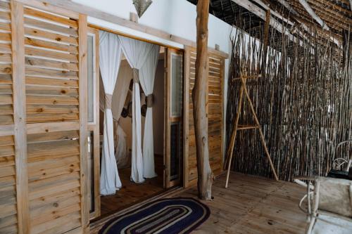 une pièce avec une tente et un plancher en bois dans l'établissement Tsunami Village, à Bwejuu