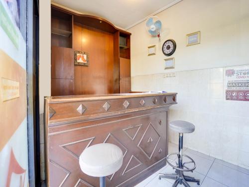 La salle de bains est pourvue d'une porte en bois et d'un tabouret. dans l'établissement OYO Life 91511 Ampel Residence Syariah, à Surabaya