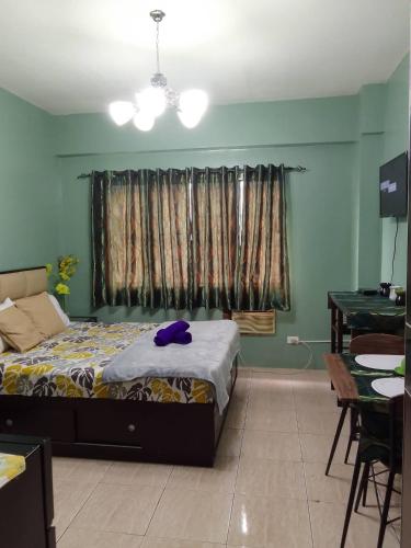 a bedroom with a bed and a table and a window at Budget Friendly Staycation in Valley Golf in Cainta