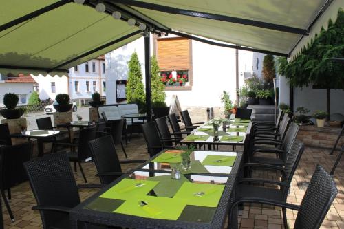 - une rangée de tables et de chaises sur la terrasse dans l'établissement Gasthof und Pension Frankenthal - garni, à Gera