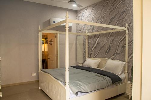 a bedroom with a canopy bed with white pillows at The Village Resort Mundra in Mundra