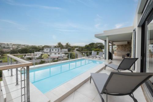 a swimming pool on the balcony of a house at Sunset Villa - brand new home 200m from the beach - top floor only in Plettenberg Bay