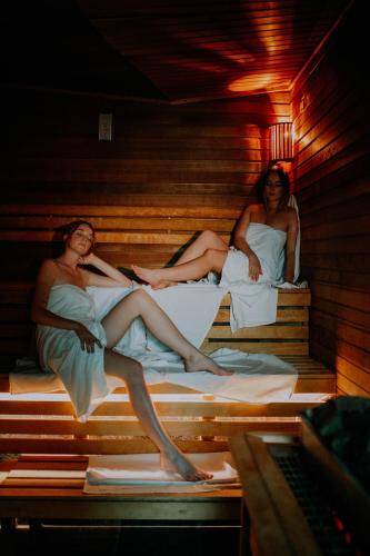 three women laying on beds in a sauna at Młyn Jacka Hotel & Spa in Wadowice