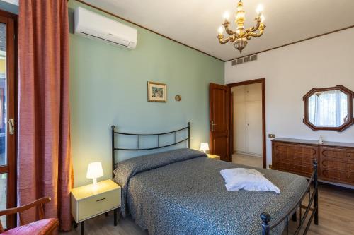 1 dormitorio con cama, espejo y lámpara de araña en Casa Cesarina, en Massa