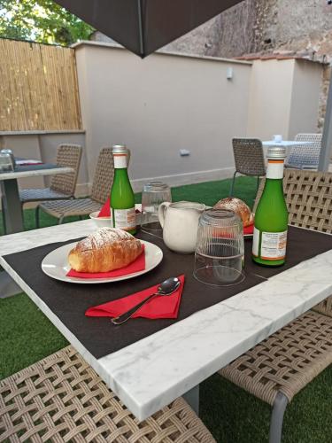 a table with two bottles of wine and bread on it at Nikis Collection Trastevere in Rome