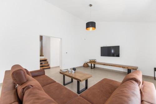 a living room with a brown couch and a table at Villa Emi in Karojba