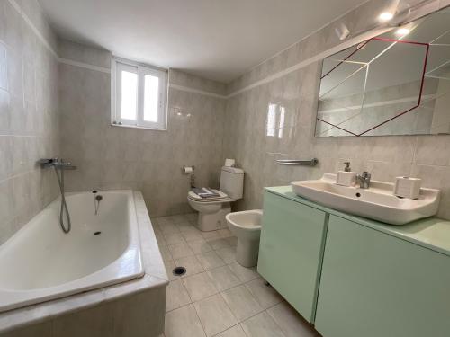 a bathroom with a tub and a sink and a toilet at MV central in Rhodes Town