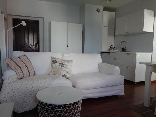 a living room with a white couch and a kitchen at Apartament 39 in Karpacz