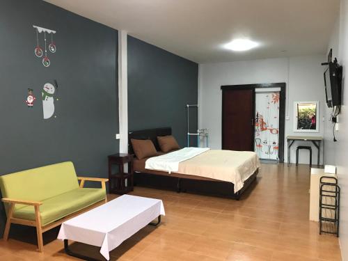 um quarto com uma cama, um sofá e uma cadeira em ชนิตา รีสอร์ท em Chanthaburi