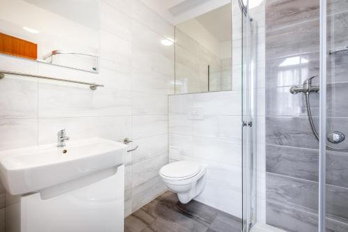 a bathroom with a toilet and a sink and a shower at Hotel Ferdinand in Mariánské Lázně