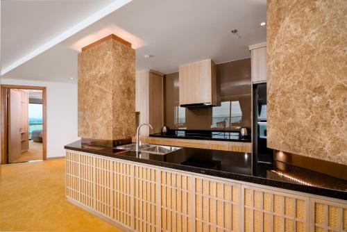 a kitchen with a black counter top and a sink at Sala Grand Tuy Hoa Hotel in Tuy Hoa