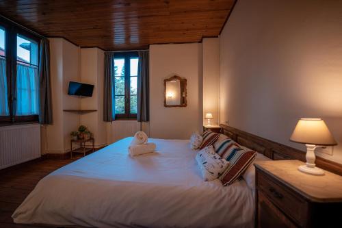 a bedroom with a large bed with white sheets and pillows at Hotel Mas de Xaxas in Camprodon