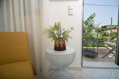 a vase of flowers on a table next to a chair at Spectacular apartment near Dance Hall/Center in Kalamata