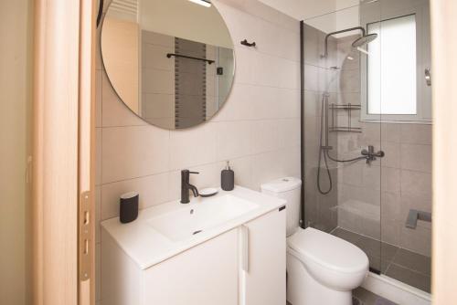 a bathroom with a sink and a toilet and a mirror at Spectacular apartment near Dance Hall/Center in Kalamata