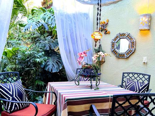 een tafel en stoelen op een patio met een spiegel bij Dickinson Guest House, Guadalajara Expo in Guadalajara