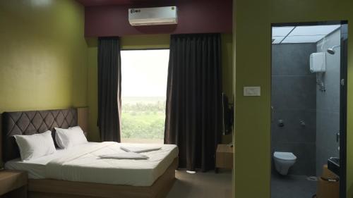 a bedroom with a bed and a window and a shower at Hotel Sai Aakanksha in Sopāra